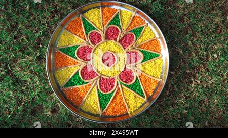 Décoration Arti thali avec riz cru coloré dans une assiette. Aarti thaali ou Pooja thali décoration fait à la main avec de la farine de blé Banque D'Images