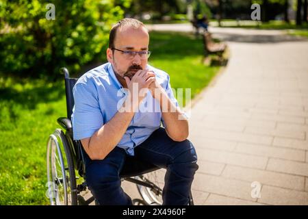 Gros plan portrait de l'homme en fauteuil roulant. Il est inquiet et réfléchi. Banque D'Images