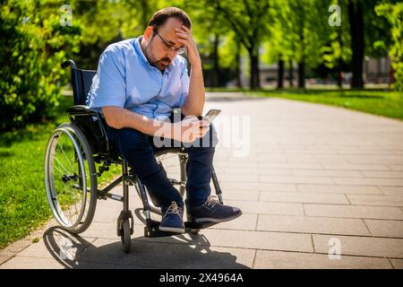 Portrait d'homme en fauteuil roulant. Il est inquiet et déprimé. Banque D'Images