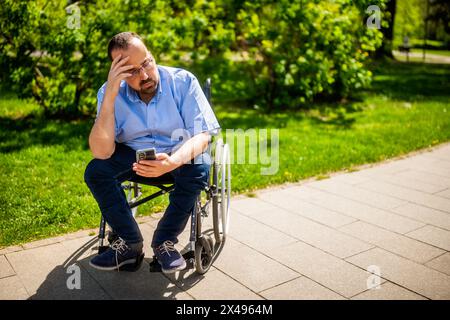 Portrait d'homme en fauteuil roulant. Il est inquiet et déprimé. Banque D'Images