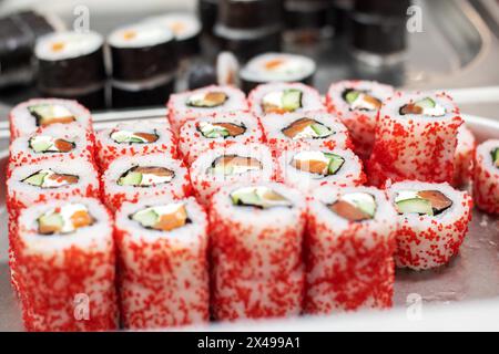 Une variété de rouleaux de sushi avec des saupoudrés rouges sur le dessus, un ingrédient populaire dans la cuisine japonaise et coréenne comme California roll ou Gimbap Banque D'Images