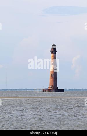 Phare de Morris Island vu de Lighthouse Inlet Heritage Preserve à l'extrémité nord de Folly Island, Caroline du Sud verticale Banque D'Images