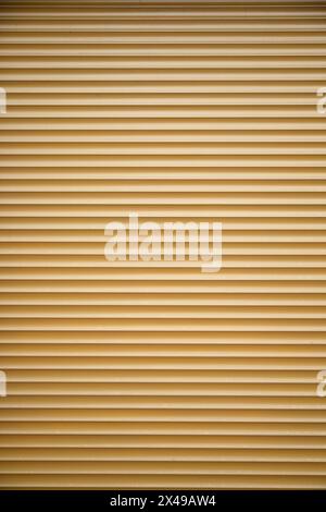 Texture de porte enroulable commerciale métallique jaune. Plan vertical, espace de copie Banque D'Images