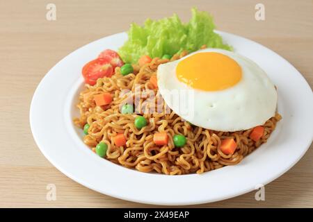 Nouilles frites Indomie Goreng avec œuf Sunny Side. Nouilles instantanées indonésiennes populaires Banque D'Images