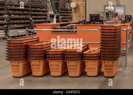 Paniers orange empilés pour transporter des achats dans un supermarché bricoleur Banque D'Images