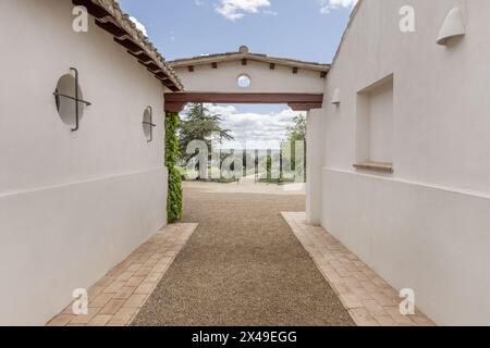 Couloir d'accès de l'extérieur au patio intérieur d'une maison de campagne de style ferme andalouse avec trottoirs en terre cuite et chemin de gravier Banque D'Images