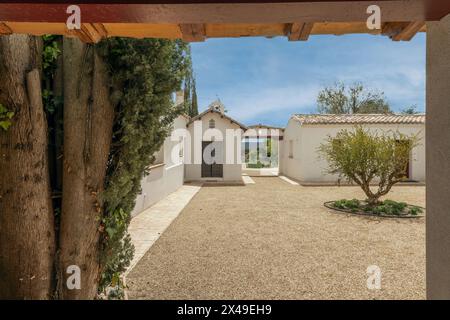 Porche couvert avec toit en bois d'une maison de campagne andalouse de style cortijo avec des trottoirs en terre cuite, allée de gravier, un olivier nouvellement planté et Banque D'Images