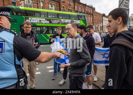 Leeds, Royaume-Uni. 01 MAI 2024. La police discute avec le contre-manifestant juif de faire des gestes avec une banane vers la foule palestinienne. Crédit Milo Chandler/Alamy Live News Banque D'Images