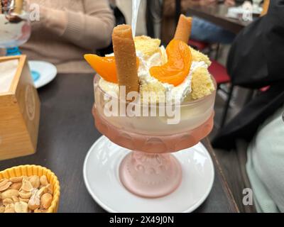 crème glacée aux fruits dans une tasse en verre avec crème et gaufres Banque D'Images