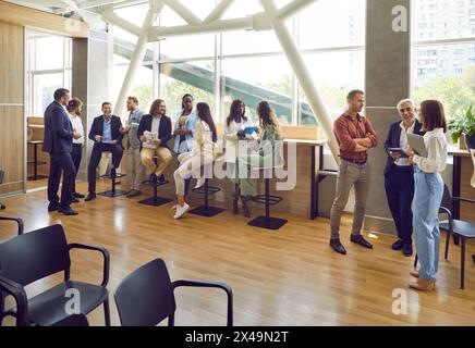 Groupe de gens d'affaires divers mener diverses conversations de discussion avec des collègues au bureau. Banque D'Images