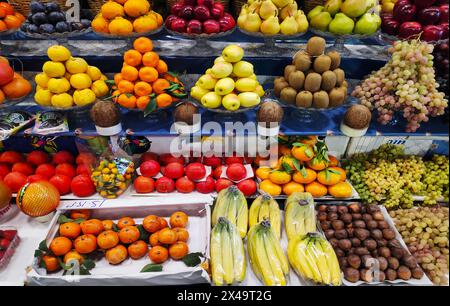 Pommes, poires, grenades, bananes, oranges, raisins kiwis kaki et autres fruits exposés Banque D'Images