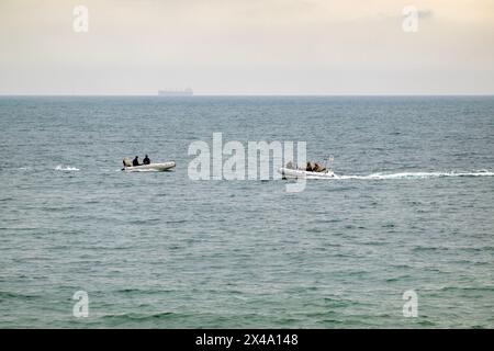 Deux bateaux gonflables naviguent l'un vers l'autre dans la mer. Banque D'Images