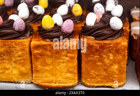 Cuisine traditionnelle britannique de Pâques, petits pains farcis frais au chocolat et œufs décoratifs dans la boulangerie Banque D'Images