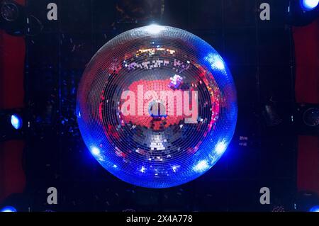 Grande boule disco classique faite de petits miroirs reflétant des lumières vives et chaudes sur le plafond d'une discothèque ou d'une salle de concert. La piste de danse peut l'être Banque D'Images