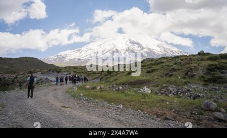 Randonneurs marchant vers le camp de base avec un énorme sommet de montagne enneigé en toile de fond, le mont Ararat en Turquie. Banque D'Images