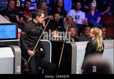 Ronnie O'Sullivan (à gauche) parle à l'arbitre Desislava Bozhilova (à droite) pendant une pause en raison de certains membres de la foule qui arrivent encore à leur place dans le match des quarts de finale contre Stuart Bingham le douzième jour du Championnat du monde de snooker Cazoo 2024 au Crucible Theatre, Sheffield. Date de la photo : mercredi 1er mai 2024. Banque D'Images