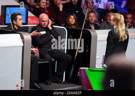 Ronnie O'Sullivan (à gauche) parle à l'arbitre Desislava Bozhilova (à droite) pendant une pause en raison de certains membres de la foule qui arrivent encore à leur place dans le match des quarts de finale contre Stuart Bingham le douzième jour du Championnat du monde de snooker Cazoo 2024 au Crucible Theatre, Sheffield. Date de la photo : mercredi 1er mai 2024. Banque D'Images