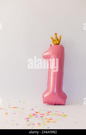 boule rose en forme de numéro un sur fond blanc Banque D'Images