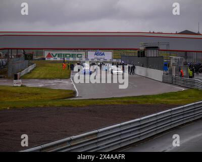 Voitures de course et officiels de course et mécaniciens sur le circuit d'Anderstorp à Småland, dans le sud de la Suède, peu avant le départ de la course. Banque D'Images