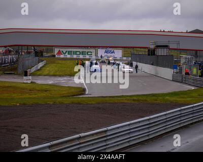 Voitures de course et officiels de course et mécaniciens sur le circuit d'Anderstorp à Småland, dans le sud de la Suède, peu avant le départ de la course. Banque D'Images