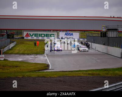 Voitures de course et officiels de course et mécaniciens sur le circuit d'Anderstorp à Småland, dans le sud de la Suède, peu avant le départ de la course. Banque D'Images