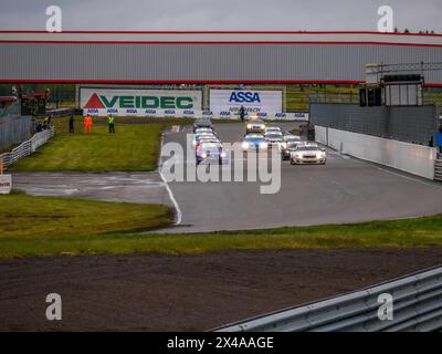 Voitures de course et officiels de course et mécaniciens sur le circuit d'Anderstorp à Småland, dans le sud de la Suède, peu avant le départ de la course. Banque D'Images