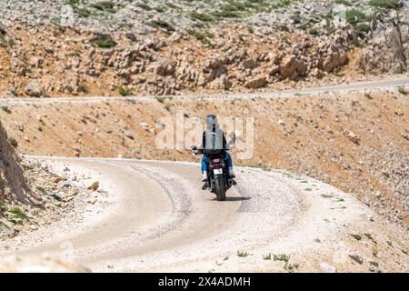 Deux amoureux sur une moto venant autour d'un virage dans la route Banque D'Images