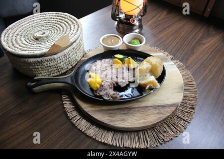 Bœuf rôti accompagné de poivrons et pommes de terre cuites au four avec tortillas, haricots et citrons à la mexicaine Banque D'Images