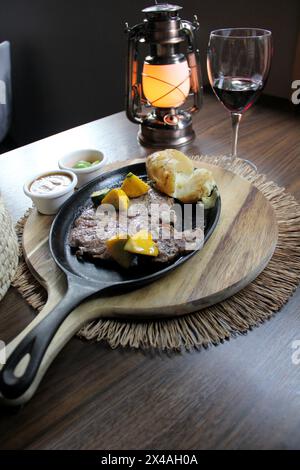 Bœuf rôti accompagné de poivrons et pommes de terre cuites au four avec tortillas, haricots et citrons à la mexicaine Banque D'Images