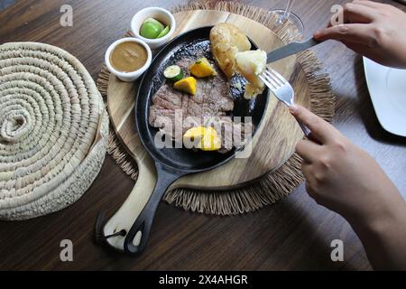 Bœuf rôti accompagné de poivrons et pommes de terre cuites au four avec tortillas, haricots et citrons à la mexicaine Banque D'Images