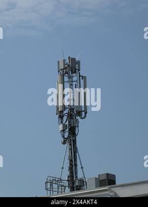 Sendemast mit Richtfunkantenne und Antennen für Handyempfang auf einem Hausdach *** mât de transmission avec antenne de relais radio et antennes pour la réception de téléphone portable sur le toit d'une maison Banque D'Images