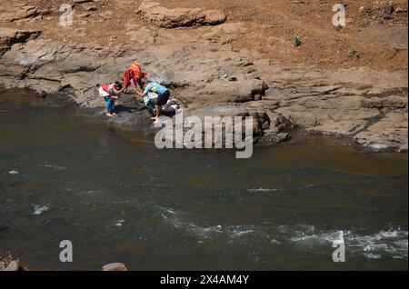 Des villageois sont vus laver des vêtements sur les rives de la rivière Vaitarna près du village de Vihigaon, Shahapur taluka du district de Thane à la périphérie de Mumbai. Chaque année pendant les mois d'été, de nombreux villages de Shahapur taluka du district de Thane font face à une grave pénurie d'eau et se tarissent. Selon les villageois, en dépit de la rivière Vaitarna à peine quelques kilomètres du village, l'eau de la rivière est détournée pour l'usage dans la ville de Mumbai et prive ainsi les villageois d'eau pendant la saison estivale chaque année. Banque D'Images