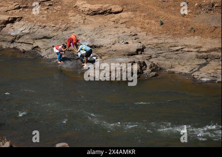 Des villageois sont vus laver des vêtements sur les rives de la rivière Vaitarna près du village de Vihigaon, Shahapur taluka du district de Thane à la périphérie de Mumbai. Chaque année pendant les mois d'été, de nombreux villages de Shahapur taluka du district de Thane font face à une grave pénurie d'eau et se tarissent. Selon les villageois, en dépit de la rivière Vaitarna à peine quelques kilomètres du village, l'eau de la rivière est détournée pour l'usage dans la ville de Mumbai et prive ainsi les villageois d'eau pendant la saison estivale chaque année. (Photo Ashish Vaishnav/SOPA images/SIPA USA) Banque D'Images