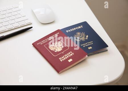 Un passeport américain et un passeport russe sur une table blanche de bureau Banque D'Images