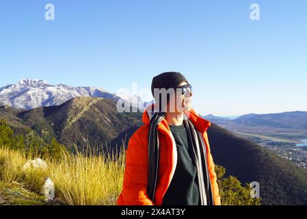 Portrait d'un touriste souriant profitant de la vue dans les montagnes. Un homme en randonnée dans les environs de la ville de Tivat (Baie de Kotor, Monténégro) Banque D'Images