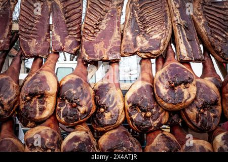 Image de jambons serbes, style prsut, sur l'affichage dans un marché de serbie, suspendu, prêt à la vente. Banque D'Images