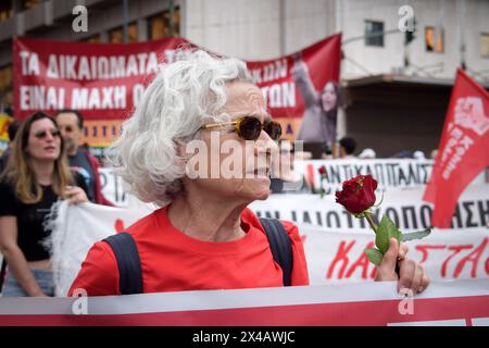 Athènes, Grèce. 01 mai 2024. Une femme crie des slogans tenant une rose rouge pendant le rassemblement de la Journée internationale des sorciers. Des milliers de personnes protestent contre « les prix élevés et la perte de salaires qui conduisent la société à un appauvrissement permanent » lors des rassemblements du 1er mai. (Photo de Dimitris Aspiotis/Pacific Press) crédit : Pacific Press Media production Corp./Alamy Live News Banque D'Images