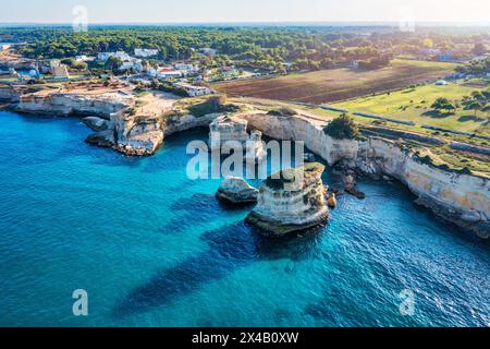 Magnifique paysage marin avec falaises, arc rocheux et empilements (Faraglioni) à Torre Sant Andrea, côte du Salento, région des Pouilles, Italie. Belles falaises et mer s. Banque D'Images