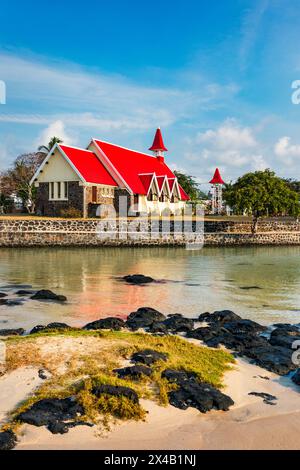 Église rouge au village de Cap malheureux, île Maurice. Notre Dame de Auxiliatrice, église rurale au toit rouge dans le village tropical Cap malheureux sur M Banque D'Images