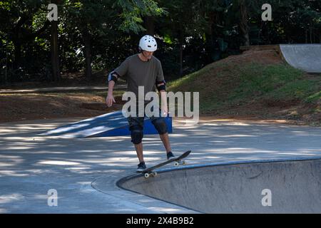 Skateboarder brésilien de 54 ans s'amusant dans un skate Park par une journée ensoleillée 2. Banque D'Images