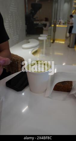 une boisson matcha et un téléphone portable et un muffin Banque D'Images