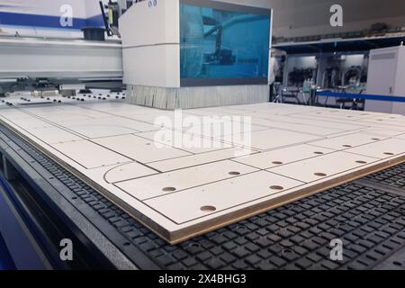 Machine moderne pour couper des panneaux de particules dans une usine de meubles. Industrie Banque D'Images