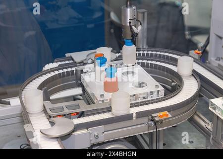 Les pilules de médecine remplissent la bouteille sur le convoyeur de machine de ligne de production à l'usine médicale. Industrie pharmaceutique, Banque D'Images
