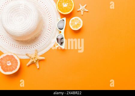 Vue de dessus de divers coquillages placés près de fruits colorés et d'accessoires d'été élégants sur fond de table. Concept d'été. Pose à plat. Vue de dessus avec c Banque D'Images