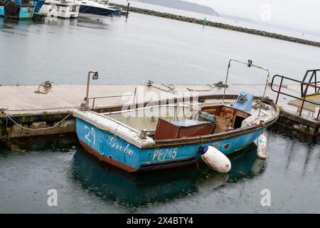 Petit bateau de pêche dans le port de Poole. Bleu et en besoin de réparation le navire raconte comment les méthodes de l'industrie dans les petites villes balnéaires ont changé. Banque D'Images