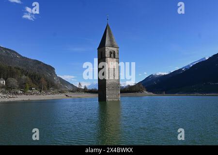 Graun im Vinschgau, Italien. Südtirol- und Italien-Urlauber kennen das Bild vom Reschensee, einem Bergsee, aus dem ein spitzer Kirchturm ragt. Es ist der Turm der Pfarrkirche : Katharina aus dem 14. Jahrhundert, die in den 50er Jahren mit dem Dorf Graun in den Fluten des Reschensees untergeging. Damals wurde ein Stausee gebaut, dem auch der Ort Reschen weichen musste. Foto : Kirchturm im Wasser bzw See *** Graun à Vinschgau, Italie Tyrol du Sud et Italie les vacanciers connaissent l'image du lac Reschen, un lac de montagne d'où s'élève une tour d'église pointue C'est la tour du XIVe siècle paris Banque D'Images