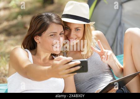 des femmes faisant un selfie à côté de la tente Banque D'Images