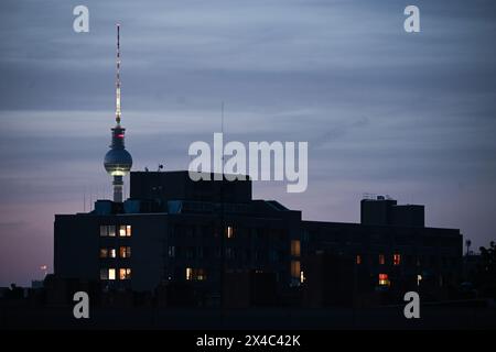 Berlin, Allemagne. 01 mai 2024. La tour de télévision peut être vue derrière des appartements éclairés dans un immeuble. Crédit : Sebastian Gollnow/dpa/Alamy Live News Banque D'Images