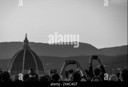 Photo en noir et blanc de touristes prenant des photos du Duomo de Florence - Cathédrale - de Piazzale Michelangelo à Florence en Toscane, Italie. Banque D'Images