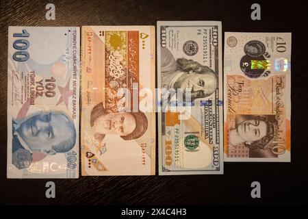 De droite à gauche : billet de 20 Go livre sterling, billet de 100 dollars américains, 5000 rials iraniens (500 tomans iraniens), 100 billets de lires turques. Banque D'Images